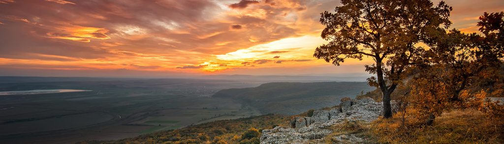 Magnificent view from a hill with an autumn forest at sunset